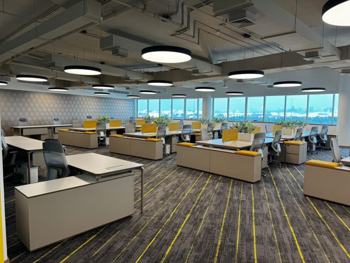 Schneider Electric Abu Dhabi office — open-plan workspace with circular pendant lighting